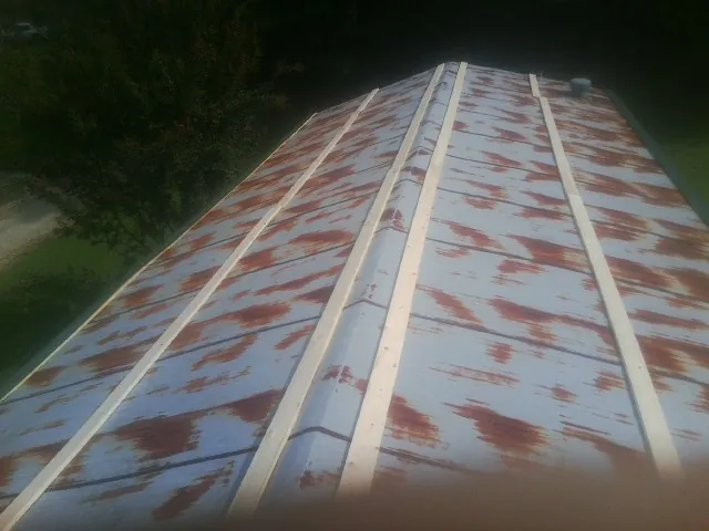 Rusted metal roof panels with new wood purlins before replacement — Storm Damage Roof Repair in Molena by Roofing Brothers