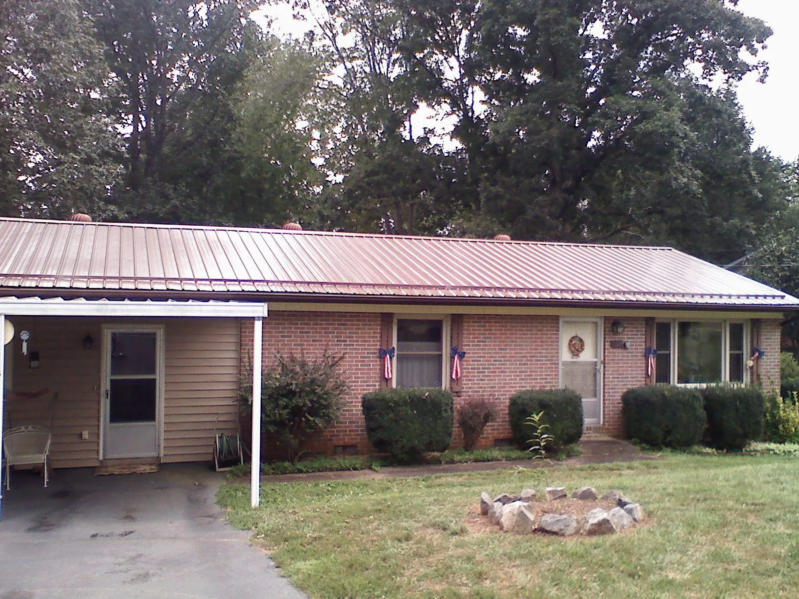 Bronze metal roof and carport on a brick ranch home — Roof Repair work by our crew in Molena